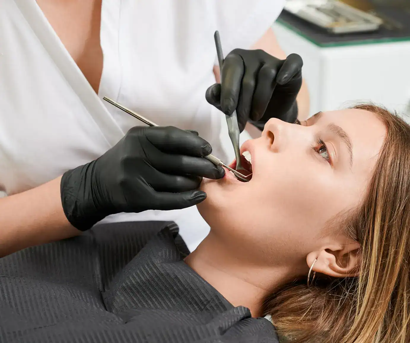 Dentist examining patient's teeth closely