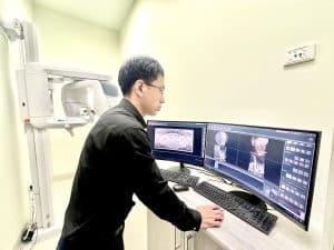 Dentist reviewing 3D X-ray of wisdom teeth in Prahran