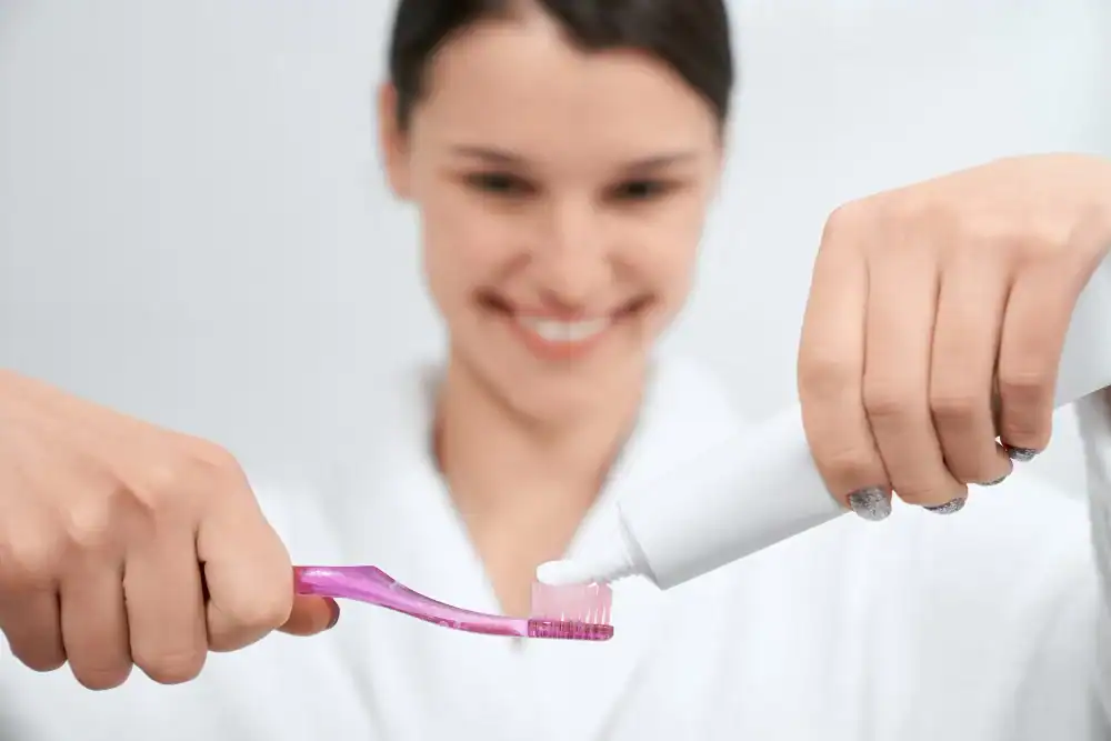 Woman brushing teeth with toothpaste