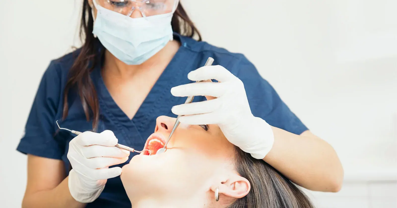 Dentist examining a patient’s mouth with a dental mirror and probe in Prahran